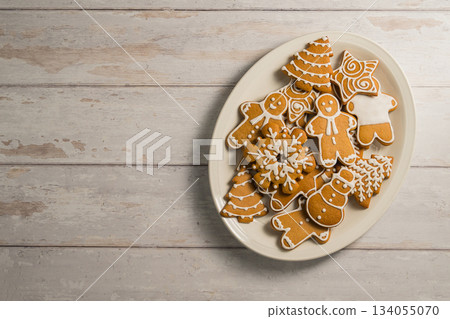 Holiday background. Christmas gingerbread cookies in different shapes in a plate, copy space Holiday background. Christmas gingerbread cookies in different shapes in a plate, copy space 134055070