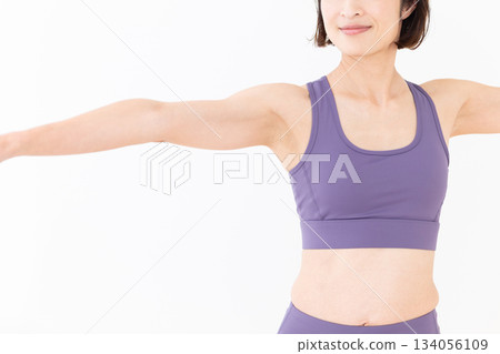 一位身穿瑜伽服的中年婦女在家中做瑜伽 134056109