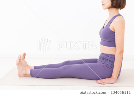 Middle-aged woman in yoga wear doing yoga at home 134056111