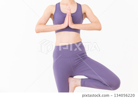 一位身穿瑜伽服的中年婦女在家中做瑜伽 一位身穿瑜伽服的中年婦女在家中做瑜伽 134056220