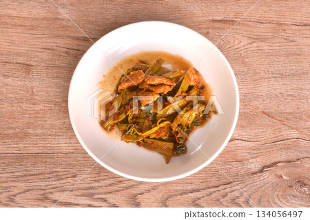 spicy stir fried Thai morning glory with slice fat pork belly in curry sauce on plate  134056497
