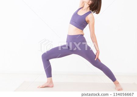 Middle-aged woman in yoga wear doing yoga at home Middle-aged woman in yoga wear doing yoga at home 134056667