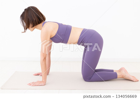 Middle-aged woman in yoga wear doing yoga at home 134056669
