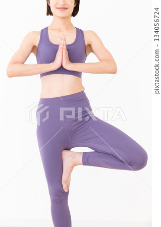 一位身穿瑜伽服的中年婦女在家中做瑜伽 134056724