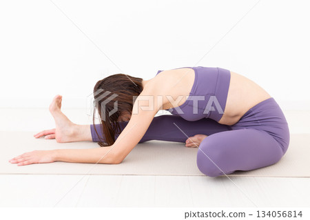 一位身穿瑜伽服的中年婦女在家中做瑜伽 134056814