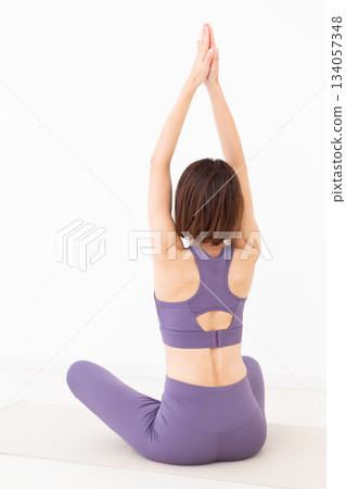 Middle-aged woman in yoga wear doing yoga at home Middle-aged woman in yoga wear doing yoga at home 134057348