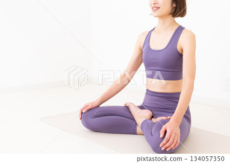 一位身穿瑜伽服的中年婦女在家中做瑜伽 134057350