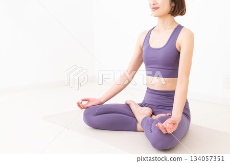 一位身穿瑜伽服的中年婦女在家中做瑜伽 134057351