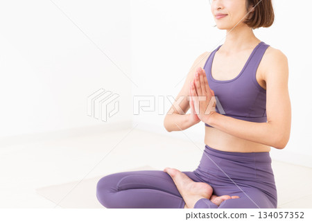 一位身穿瑜伽服的中年婦女在家中做瑜伽 134057352