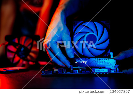 The technician is installing DDR5 RAM onto the motherboard. The technician is installing DDR5 RAM onto the motherboard. 134057897