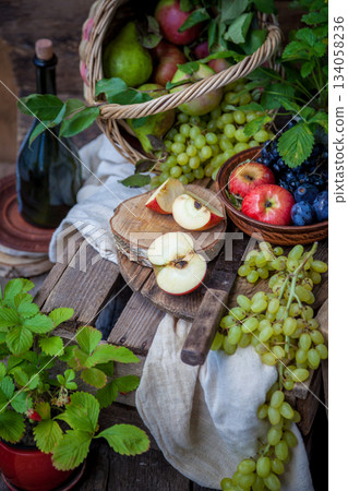 Autumn still life. Fruits and berries. Apples, grapes, strawberries, plums on a wooden table. Country style. Idle healthy vitamin food. Fruit harvest. Old knife. An apple in a basket. Autumn still life. Fruits and berries. Apples, grapes, strawberries, plums on a wooden table. Country style. Idle healthy vitamin food. Fruit harvest. Old knife. An apple in a basket. 134058236