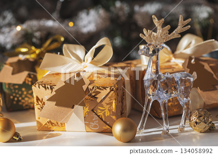 Crystal Reindeer with Gold Antlers and Christmas Gifts in Festive Interior 134058992