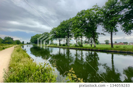 A Scenic View of a Beautiful and Peaceful Canal, Surrounded by Lush, Vibrant Green Trees 134059283