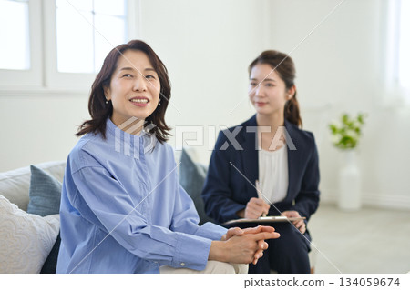一位年輕女商人向一位中年婦女解釋 134059674