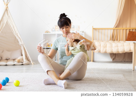 Mother checking baby temperature with gentle care while holding thermometer Mother checking baby temperature with gentle care while holding thermometer 134059928
