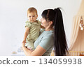 Loving mother holding her infant baby in bright home interior 134059938