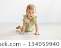 Baby crawling on floor toward the camera in bright minimal room 134059940