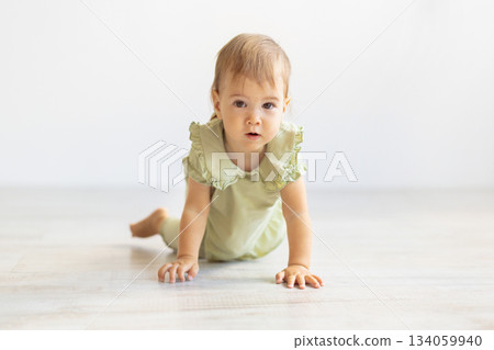 Baby crawling on floor toward the camera in bright minimal room Baby crawling on floor toward the camera in bright minimal room 134059940
