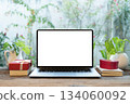 Laptop and gift box and potted plant on wood desk 134060092
