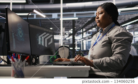 Data center computer scientist using PC to monitor artificial intelligence visualization. Server farm IT professional overseeing rigs powering machine learning processes, camera A 134060256