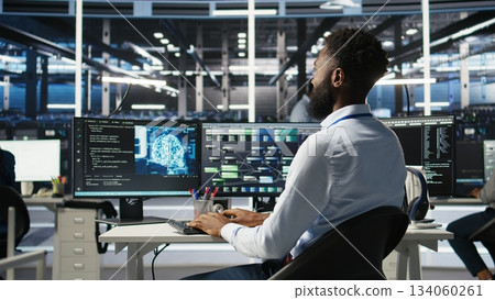 Data center programmer uses machine learning node tree program to identify equipment issues. Server hub worker reviewing artificial intelligence data analysis graph to minimize failures, camera A 134060261