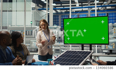 Photovoltaics plant researchers doing meeting, looking at chroma key monitor, evaluating energy production. Experts optimize factory gear energy output, looking at isolated screen display, camera A 134060386