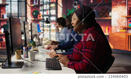 Senior account manager teaching intern how to talk with customers to identify sales opportunities. Experienced team leader helping new trainee in office to generate leads, camera B 134060403