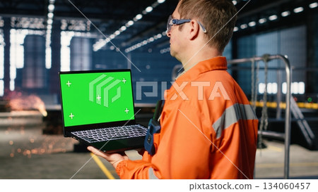 Green screen laptop with industrial staff in a workshop manages fabrication tools, showing engineering concepts, workforce responsibility and the heavy operation requirements. Green screen laptop with industrial staff in a workshop manages fabrication tools, showing engineering concepts, workforce responsibility and the heavy operation requirements. 134060457