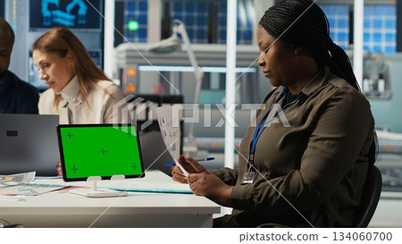Factory engineer tripping while study assembly lines schematics, refining production layouts using green screen tablet. Experts outlining industrial plant configurations using mockup device, camera B Factory engineer tripping while study assembly lines schematics, refining production layouts using green screen tablet. Experts outlining industrial plant configurations using mockup device, camera B 134060700