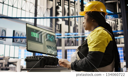 Smart solar panels factory worker typing on PC keyboard, testing automated systems, doing maintenance. Woman in industry 4.0 photovoltaics plant using computer to inspect gear and fix bugs, camera A Smart solar panels factory worker typing on PC keyboard, testing automated systems, doing maintenance. Woman in industry 4.0 photovoltaics plant using computer to inspect gear and fix bugs, camera A 134060722