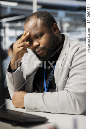 Overworked data center engineer feels strain after working all day to verify parameters. Tired server hub worker getting burnout headache while inspecting configurations to ensure optimal performance Overworked data center engineer feels strain after working all day to verify parameters. Tired server hub worker getting burnout headache while inspecting configurations to ensure optimal performance 134060814