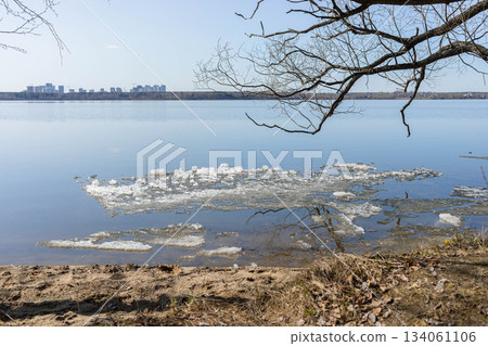 Tranquil lakeside view with ice fragments and sandy shore in spring 134061106