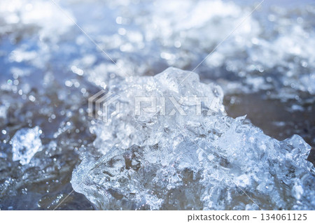 Close-up of shimmering ice crystals reflecting sunlight on water surface 134061125