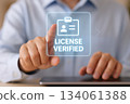 A Person Utilizing a Digital Interface to Confirm License Verification with a Touchscreen Display Indicating Successful Authentication and Approval Process 134061388