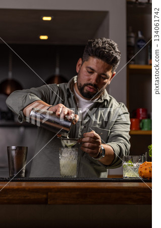 Professional bartender preparing a drink Professional bartender preparing a drink 134061742