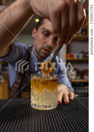 Bartender garnishing a cocktail Bartender garnishing a cocktail 134061761