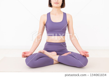 Middle-aged woman in yoga wear doing yoga at home Middle-aged woman in yoga wear doing yoga at home 134061834