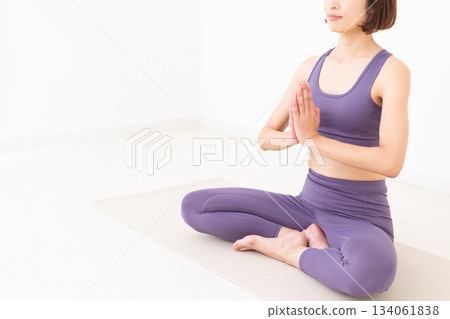 Middle-aged woman in yoga wear doing yoga at home Middle-aged woman in yoga wear doing yoga at home 134061838