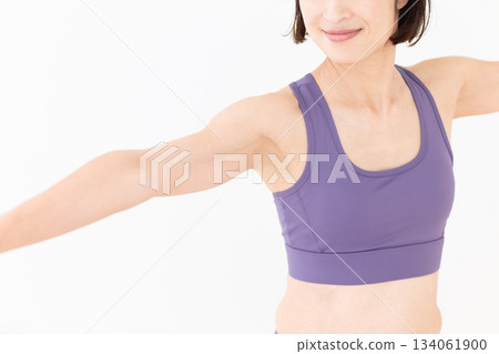 一位身穿瑜伽服的中年婦女在家中做瑜伽 134061900