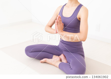 一位身穿瑜伽服的中年婦女在家中做瑜伽 134061902
