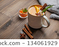 Sea buckthorn herbal tea in a cup on a wooden background with spices, berries and napkin 134061929