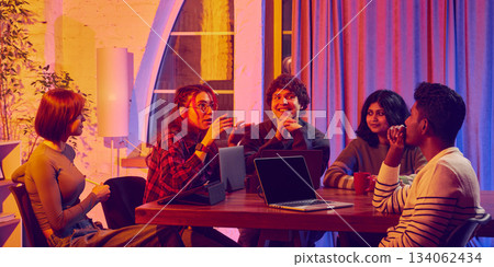 Group collaborating with diverse tech devices during creative meeting. Group collaborating with diverse tech devices during creative meeting. 134062434
