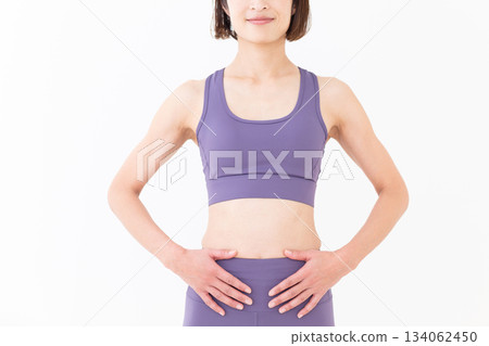Slim belly of a middle-aged woman in yoga wear Slim belly of a middle-aged woman in yoga wear 134062450