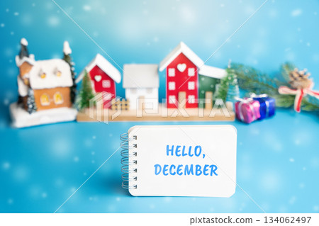Notes Hello December and a Christmas tree and a houses with snow. Concept of the beginning of a new winter season 134062497