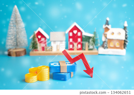 Coins and a stack of money with a downward arrow. Concept of winter budget cuts, economic downturn, and crisis. Low prices and interest rates. Business and finance Coins and a stack of money with a downward arrow. Concept of winter budget cuts, economic downturn, and crisis. Low prices and interest rates. Business and finance 134062651