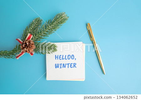 Notes Hello winter and a Christmas tree branch and pen. Concept of the beginning of a new winter season and new month Notes Hello winter and a Christmas tree branch and pen. Concept of the beginning of a new winter season and new month 134062652