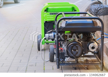 Diesel power generator. Business uses two mobile generators. Outdoor power supply generator placed on street sidewalk. Energy independence. Diesel power generator. Business uses two mobile generators. Outdoor power supply generator placed on street sidewalk. Energy independence. 134062667