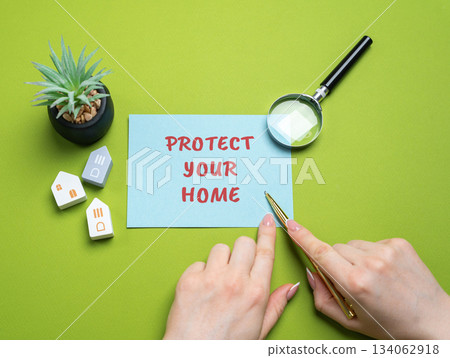 Protect your home concept. Taking measures to keep a house safe from risks such as theft, fire, accidents, or natural disasters, ensuring security and peace of mind. A woman points to an inscription 134062918