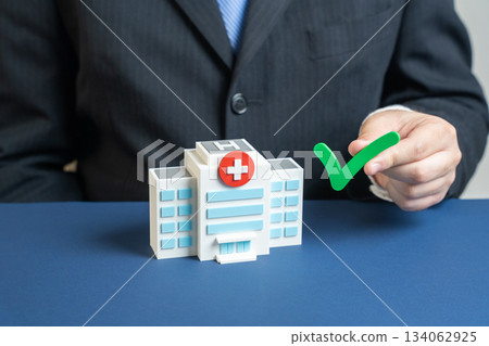 Medical building with a green check mark. Representing healthcare certification, insurance approval, quality standards, hospital accreditation, patient safety, and trusted medical services concept. 134062925