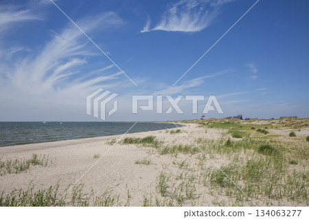 Beach scene at Marker Wadden in The Netherlands with sand, water, and clouds visible in the sky 134063277